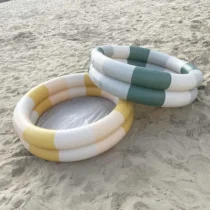 Piscină gonflabilă pentru copii 120 cm cu două inele, dungi pastelate galben-bej și verde, amplasată pe nisip